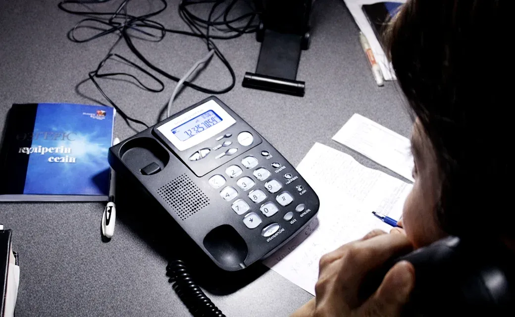 Call center phone and counselor taking notes.