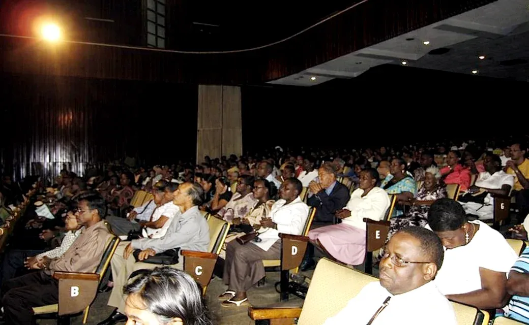 Large audience seated in an auditorium at a Power to Change Guyana event.