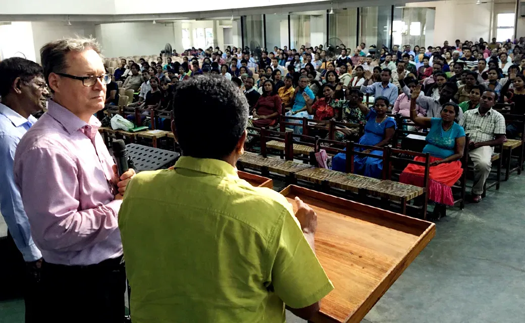 Speaker addressing a large audience in a church hall in Sri Lanka.