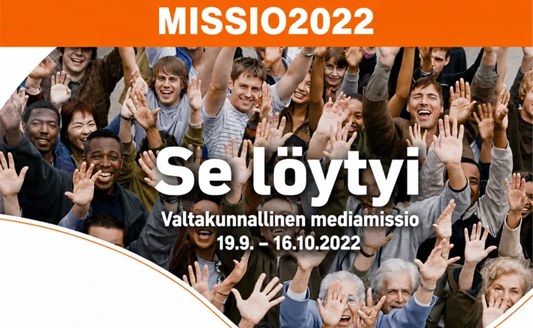 People walking in a snowy city square beside a bus shelter showing a Finnish-language campaign poster.