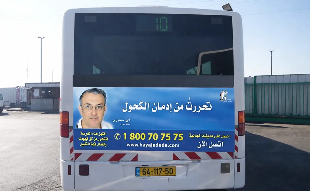 Blue Arabic-language campaign billboard beside a road in Nazareth