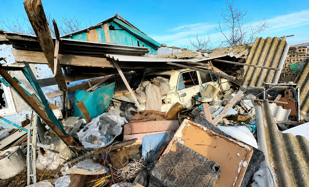 A bombed-out home and destroyed car in a war-damaged neighborhood near Kherson.