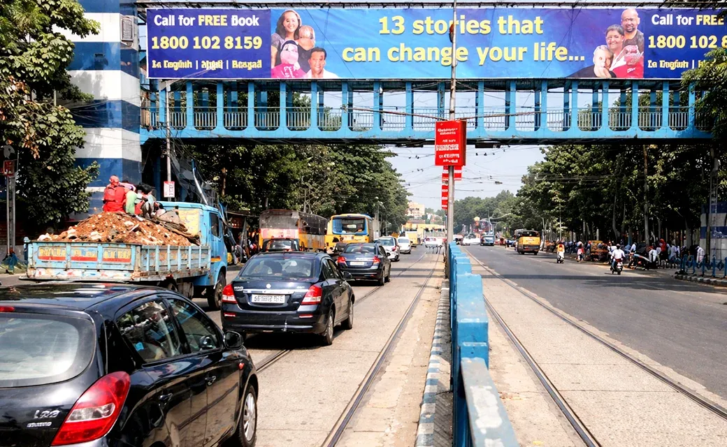 Mega City Media Campaign billboard in Calcutta advertising a toll-free number for a free book.