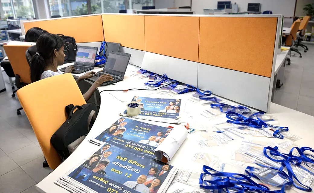 Call centre workstations with laptops and campaign materials on a table.