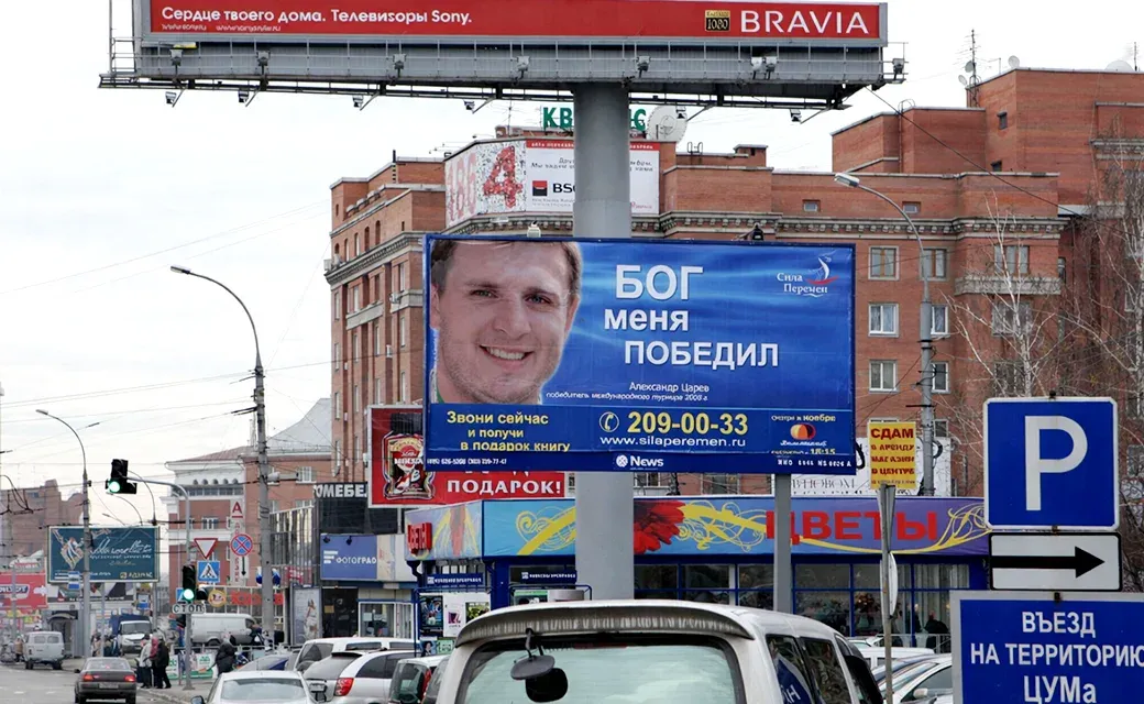 Large Russian-language billboard displayed above a busy city street in Russia