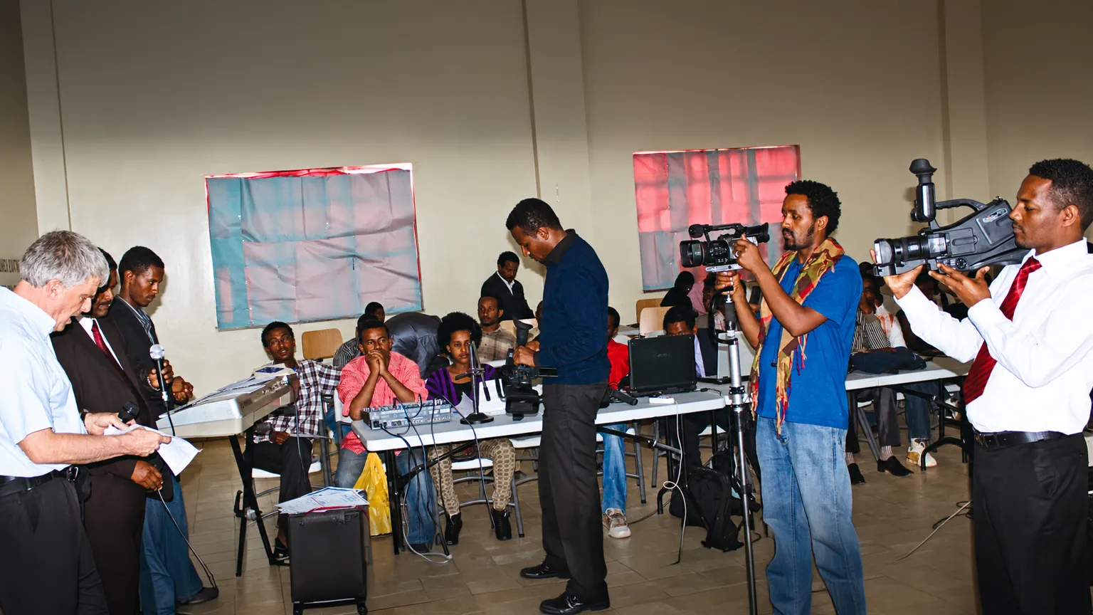 Local media production team preparing cameras and filming equipment during a Christian television production training session.