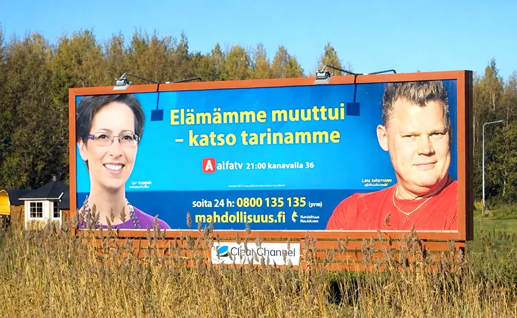 A large roadside billboard in Finland promoting a life-change story and a phone number and website to respond.